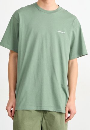 Green cotton t-shirt with short sleeves, crew neck, and small white logo on the left chest. Smooth texture and relaxed fit.