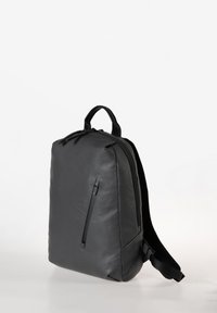 Zaino nero realizzato in materiale liscio e durevole. Presenta una tasca anteriore con zip e due spallacci regolabili. Design minimalista.