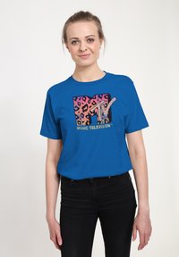 Camiseta de algodón azul royal con un logo de MTV en estampado de leopardo multicolor en el centro. Mangas cortas y cuello redondo.