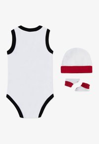 Body bianco in cotone con bordi neri, abbinato a un cappello bianco con polsino rosso e due paia di calzini bianchi con dettagli rossi.