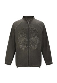 Olivengrøn jakke med høj krave, lynlås lukning og broderet kranie-design på forsiden. Har lange ærmer og en glat tekstur.