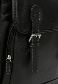 Borsa a tracolla in pelle nera con superficie texturizzata, tasca con zip e cuciture bianche a contrasto sulla tracolla e sul flap.