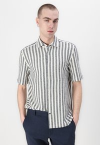 Camicia a maniche corte con bottoni, caratterizzata da strisce verticali alternate nere e bianche, realizzata in tessuto texture, con colletto a punta.