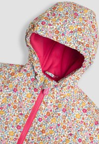 Giacca con motivo floreale che presenta una zip rosa e una fodera interna coordinata. Design con cappuccio caratterizzato da colori vivaci di fiori rosa, arancione e blu su uno sfondo crema.