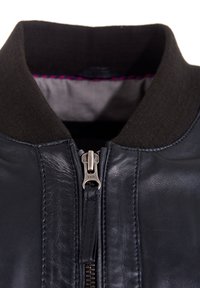 Zwarte leren bomberjack met een gestructureerde donkere kraag, voor YKK-rits en zichtbare stikdetails. Interieur heeft een contrasterende voering.