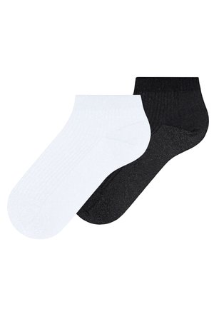 Een paar enkelsokken, één wit en één zwart, plat uitgespreid tegen een witte achtergrond.