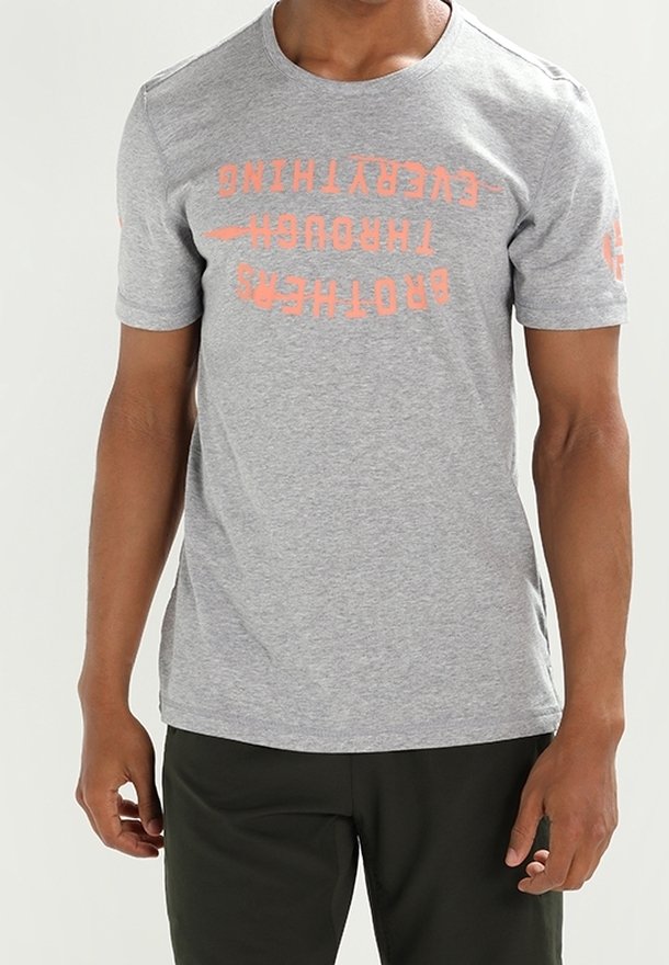 T-shirt en coton gris à manches courtes, avec des graphismes textuels orange sur le devant et la manche droite ; col rond, coupe régulière.