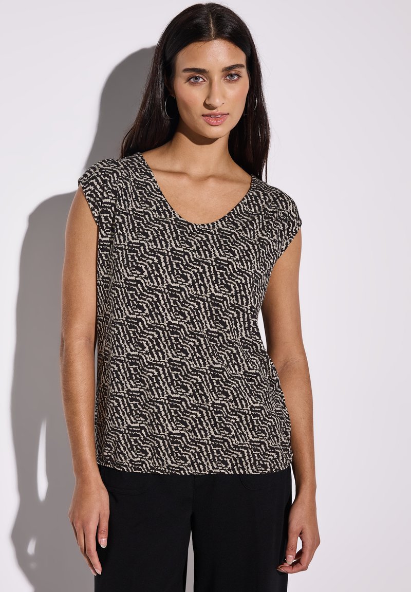 Top de manga corta en negro y crema con un patrón ondulado. Presenta un escote de corte amplio y un ajuste relajado. Textura suave y tela ligera.