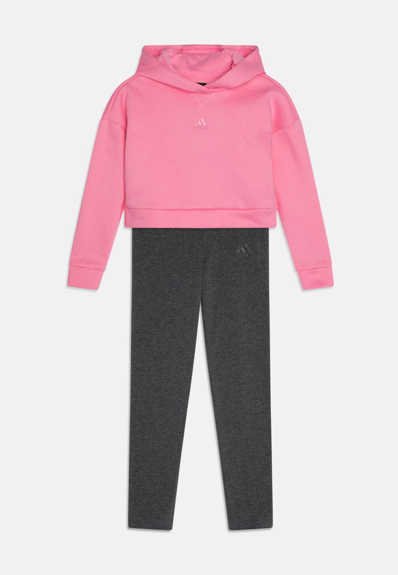 Felpa cropped rosa con logo, abbinata a leggings grigio scuro; entrambi realizzati in morbido tessuto misto cotone, con polsini a coste e vestibilità slim.