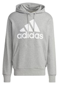 Felpa grigia realizzata in misto cotone, con tasca a marsupio, cappuccio con cordino e un grande logo bianco di Adidas sul davanti.