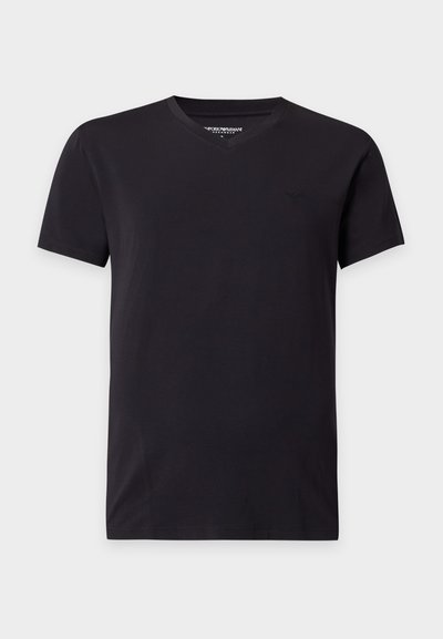 Απλό μαύρο T-shirt με κοντά μανίκια και V-λαιμόκοψη με μικρό διακριτικό λογότυπο στο αριστερό στήθος, εμφανισμένο σε ουδέτερο γκρι φόντο.