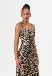 Leopard print satin dress with a fitted bodice, delicate spaghetti straps, and a smooth, flowing silhouette.