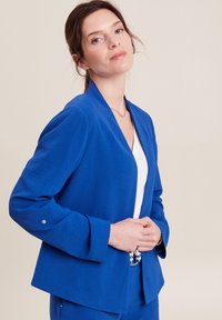 Blazer tailored blu in tessuto testurizzato, con una vestibilità rilassata, revers ampi e dettagli con bottoni argento sulle maniche.