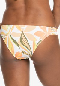Bikini-bottem met een bloemenpatroon in oranje, geel en groen op een witte achtergrond. Glad stof met ruches aan de zijkant.