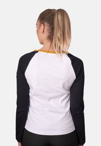 Langarmshirt mit weißem Körper, schwarzen Ärmeln und gelbem Kragen. Baumwollmaterial mit lockerer Passform und schlichtem Design.
