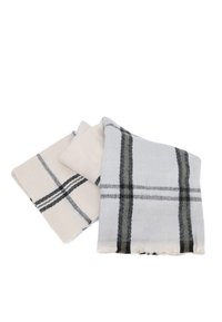 Due coperte: una beige con linee nere, una grigia chiara con un motivo a quadri grigi scuri. Entrambe hanno bordi frangiati e una texture morbida.