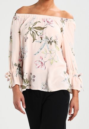 Blouse décolletée en rose clair avec des motifs floraux. Dotée de manches évasées avec des accents à nouer. Tissu doux, coupe décontractée.