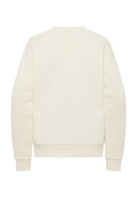 Felpa color crema con vestibilità rilassata, scollatura rotonda e spalle abbassate. Texture morbida, polsini e orlo a coste. Design semplice sulla schiena.