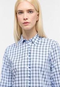 Blue and white checkered shirt with a button-down collar, blue buttons, and a soft texture. Features a lightweight, tailored design.