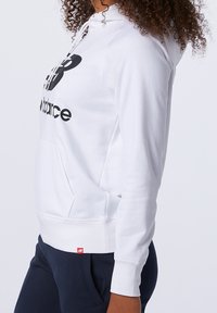 Felpa bianca in cotone con logo grafico nero, cappuccio regolabile con lacci, tasca a marsupio frontale, polsini e orlo a costine, con un'etichetta logo rossa.