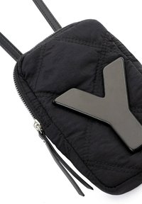 Sac en tissu noir matelassé avec un logo "Y" noir bien visible, fermeture éclair et deux fines bretelles. Equipé de détails en métal argenté.