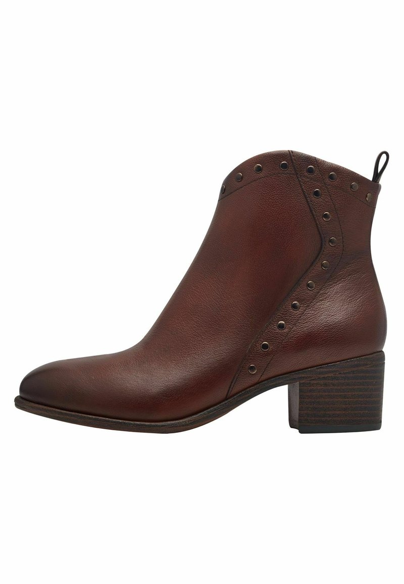 Bottine en cuir marron avec talon empilé bas et clous métalliques décoratifs le long du bord supérieur et de la couture latérale.