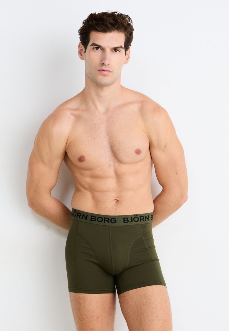 Olivové boxerské trenýrky s čiernym pásom označeným "BJÖRN BORG." Vyrobené z jemného, elastického materiálu, s priliehavým strihom.