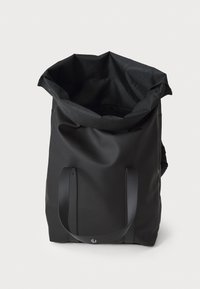 Black tote bag made from waterproof material, featuring a roll-top design, sturdy handles, and a textured finish. No visible hardware.