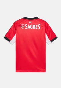 Crvena sportska majica s crnim ovratnikom, bijelim detaljima na rukavima i istaknutim natpisom "SAGRES" na poleđini. Izrađena od prozračnog materijala.