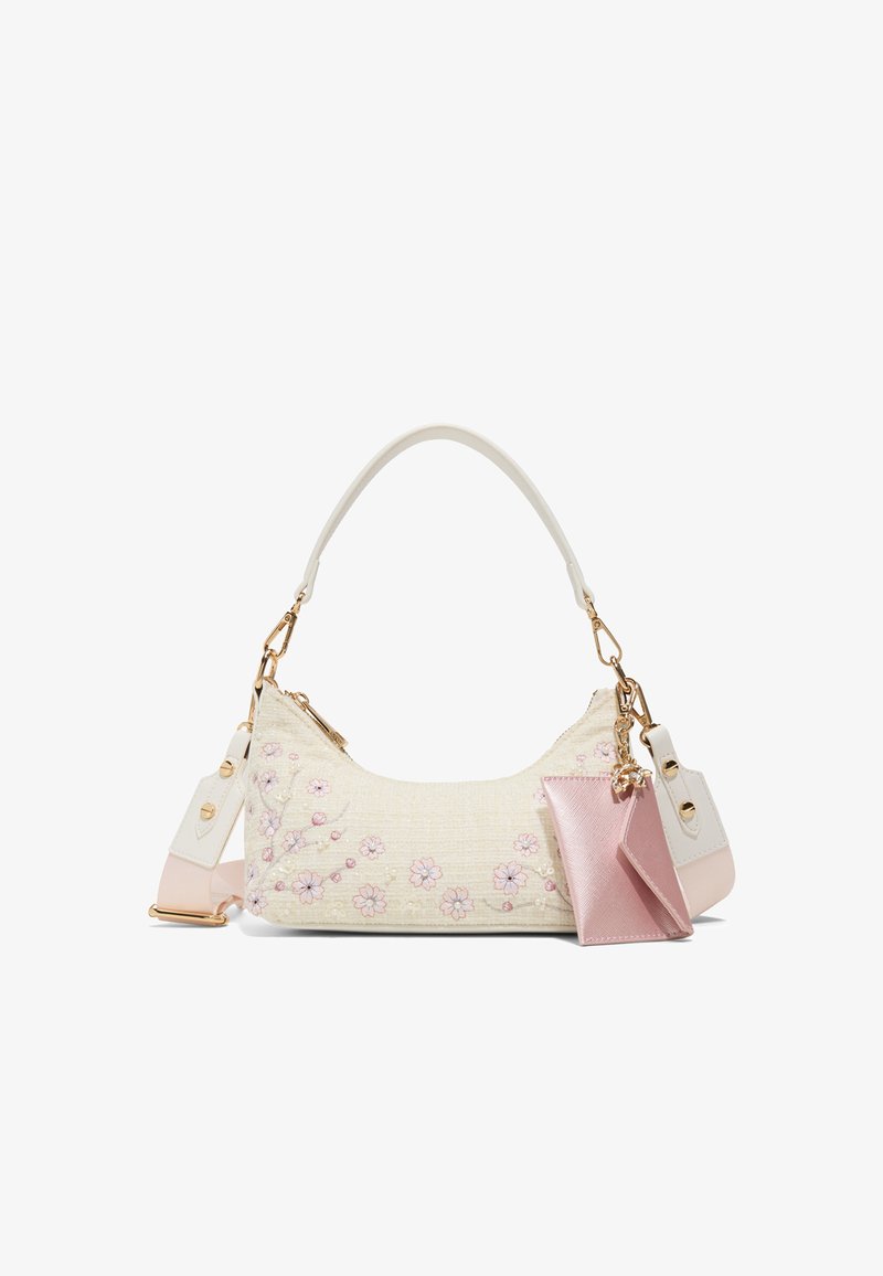 Small cream handbag with pink floral embroidery, white handle, adjustable pink strap, and attached pink cardholder charm.
