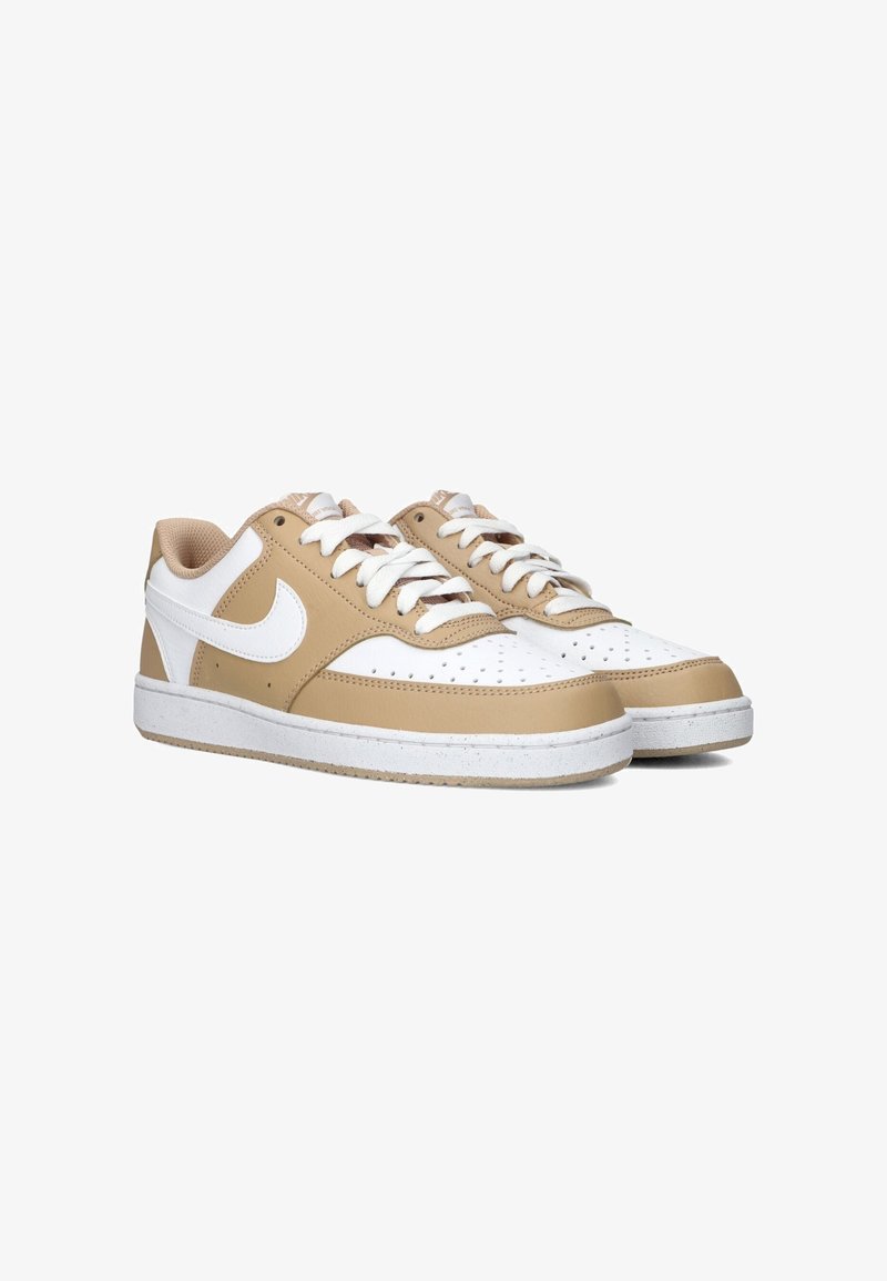 Lichtbruine en witte lage sneakers met een leren afwerking, geperforeerde neus, witte veters en een gestructureerde rubberen zool. Ronde logo aan de zijkant.