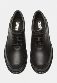Black leather shoes with a smooth surface, round toe, and contrasting rubber sole. Features classic lace-up design and brand logo inside.