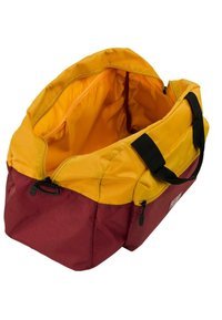 Bolsa de deportes con fondo burdeos y parte superior amarilla. Hecha de tela con una textura suave, cuenta con dos asas negras y un cierre de cremallera.