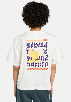 Hvit bomulls t-skjorte med et fargerikt grafisk design på baksiden, inkludert en gul løve og tekst i lilla og oransje.