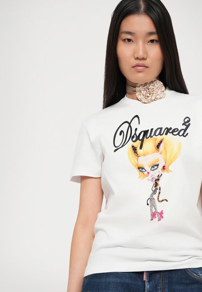 T-shirt bianco in cotone con una grafica colorata di un cartone animato che presenta un personaggio stilizzato. Collo rotondo e maniche corte. Jeans in denim visibili.
