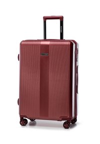 Red hard-shell suitcase with vertical ridges, retractable handle, and four wheels. Features a brand logo on the front and side grips.