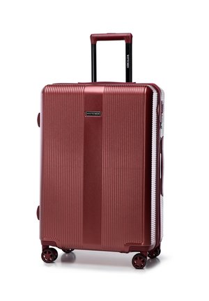 Red hard-shell suitcase with vertical ridges, retractable handle, and four wheels. Features a brand logo on the front and side grips.