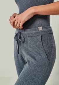 Graue, weiche Strick-Jogginghosen mit elastischem Bund, Kordelzug, gerippter Textur und seitlichen Taschen. Logotag am Bund.