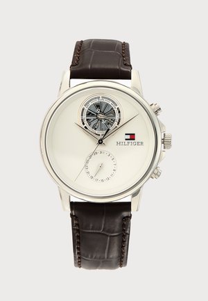 Herrenuhr mit weißem Zifferblatt, zwei Subzifferblättern für Tag und Datum, silbernem Gehäuse, braunem Lederarmband und Tommy Hilfiger-Logo.