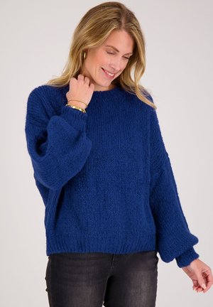 Zacht blauw gebreide trui met een textuurrijke afwerking, ronde halslijn en ballonmouwen. Voorzien van geribbelde manchetten en zoom.