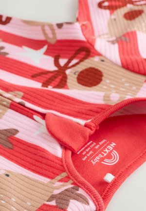 Tessuto a righe rosso e rosa con motivi di renne e stelle bianche, dotato di un fiocco decorativo e di un'etichetta vicino al collo.