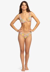 Bikini set z rožnatim vzorcem v roza, rumeni in zeleni barvi; trikotni top z širokimi naramnicami, spodnji del z nizkim pasom, gladka tekstura tkanine.