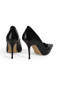 Schwarze hochglänzende Leder-High Heels mit spitzer Zehenpartie, schlankem Stilettoabsatz und einem schlanken Design. Strukturierte Oberfläche an den Außenseiten.