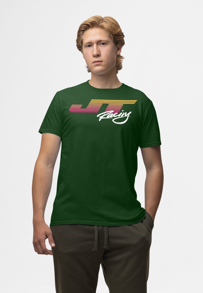 Zelené bavlněné tričko s grafickým designem, na kterém je bílé kurzívou napsáno "JT Racing" a horizontální pruhy v žluté a růžové barvě na hrudi.