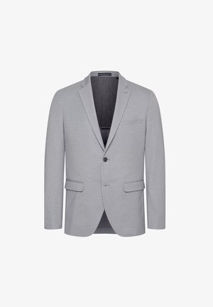 Helehall blazer, millel on nurgeline krae, ühe nööbiga kinnitamine ja kaks esikotti. Tekstureeritud kangas, millel on peen muster.