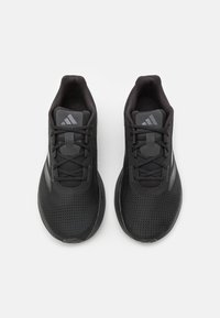 Le scarpe sportive nere presentano una tomaia in mesh traspirante, una punta rotonda e un sistema di allacciatura sicuro. Accentuate da dettagli e marchi grigi.
