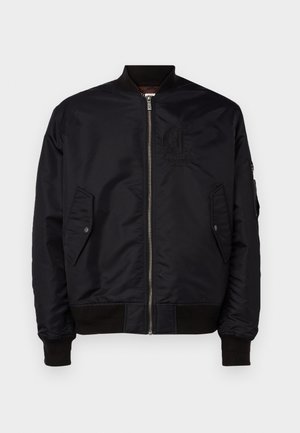 Sort bomberjakke lavet af glat stof. Har en frontlynlås, ribbede manchetter og to sidelommer. Inkluderer et logodetalje på brystet.