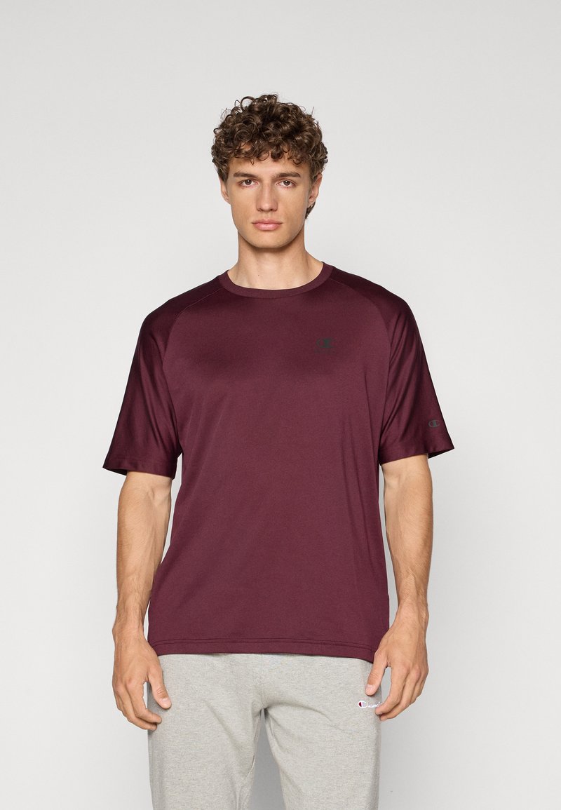 Bordeaux kortemouw t-shirt met ronde hals, gemaakt van zachte stof. Heeft een raglan-ärm ontwerp en een kleinigheid logo op de borst.
