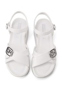 Sandali bianchi con cinturini incrociati, una fibbia rettangolare di colore argento e una suola piattaforma. Realizzati in materiale liscio, presentano un design semplice.