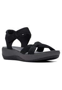 Schwarze Sandalen mit einem geknoteten Riemendesign, weichem Obermaterial und Wedge-Sohle. Verfügt über verstellbare Riemen für eine individuelle Passform.